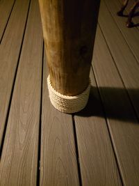 Detail of a dark grey composite deck with a decorative rope-wrapped wooden column, demonstrating custom deck enhancements in Palm Bay, Florida.