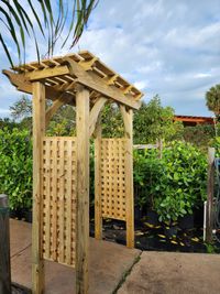 Simple yet stylish wooden garden arbor by a top-notch Palm Bay exterior construction company, adding charm to a Florida home's landscape.