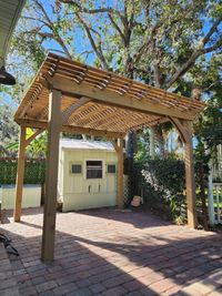 Sun-drenched backyard pergola by a Palm Bay exterior specialist, providing a perfect blend of shade and style for a Florida home.