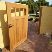 Solid wood entry gate showcasing detailed craftsmanship, designed by Palm Bay's leading exterior construction business for a Brevard County residence.