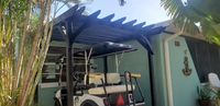 Carport converted to a tropical oasis with wooden pergola over a golf cart, reflecting Palm Bay's versatility in outdoor space enhancement.