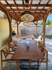 Outdoor dining under a wooden pergola with hanging lanterns, providing a perfect blend of rustic charm and functionality for a Palm Bay residence.